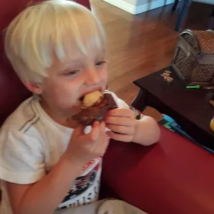  a young boy eating a donut