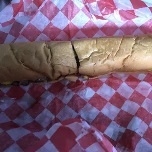 a sandwich on a red and white checkered paper