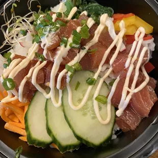 Poke bowl with tuna, cucumber, carrots, seaweed salad, peppers.