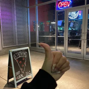 a hand pointing at a sign