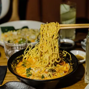 a bowl of noodles with chopsticks