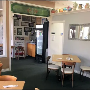 The small dining room features many knick-knacks, homestyle pictures, and family photos.