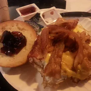 Bacon, egg, and cheese on A Bagel with a side of grape jelly. Delicious and look at all that BACON.