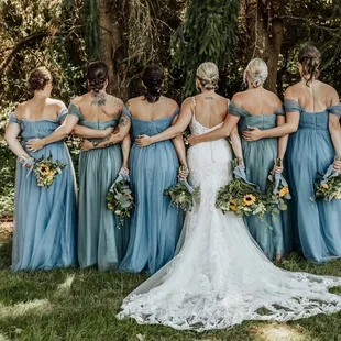 The first to the left of the bride. Can barely tell she moved the zipper all around.
