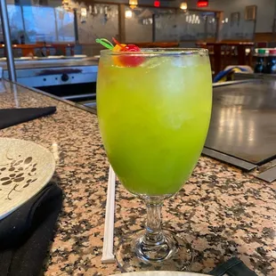 a green drink with a garnish garnish