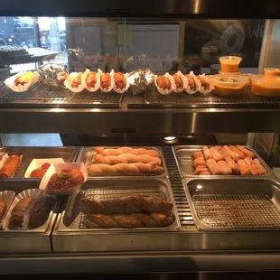 a display of hot dogs and other foods