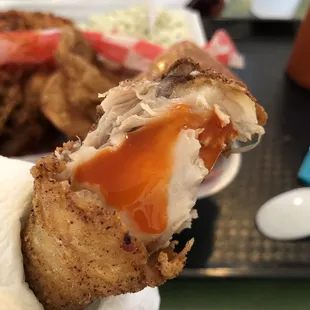 a hand holding a fried chicken sandwich