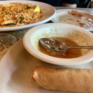 Chicken pad Thai in back and spring roll with peanut sauce