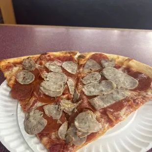 Pepperoni and sausage pizza by the slice, sausage slices are pale, white, and soft, not crispy and hot, but cold..