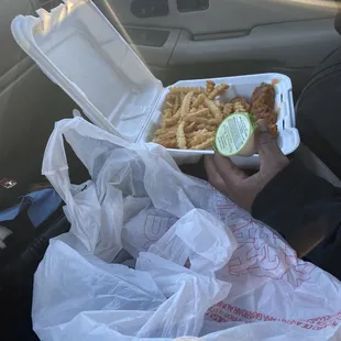 a person holding a tray of food