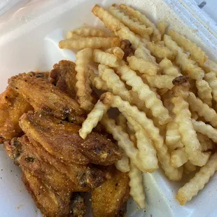 fried chicken and french fries in a styrofoam container