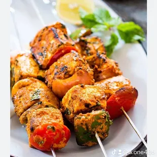 a plate of chicken skewers