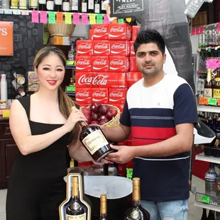 a man and woman holding a bottle of wine