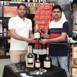 two men holding bottles of wine