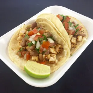 two tacos in a styrofoam container
