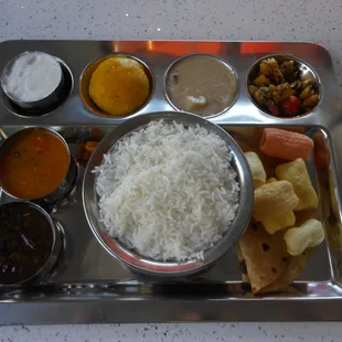thali with rice,pickle,bread,snack,sweet,veggie curry,lentil,spicy soup,yogurt and creamy savory dish