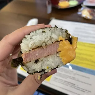 a hand holding a half eaten sandwich