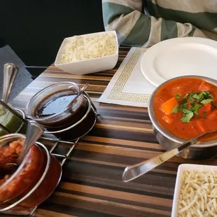 chicken vindaloo with three condiments for appetizers
