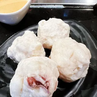a plate of food with a bowl of sauce in the background
