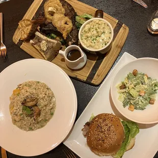 Top R to L: bone-in angus ribeye $64.95 KYD + lobster tail $10 KD, seafood risotto $37.95 KYD, dry-aged burger w/side salad $19.95 KYD