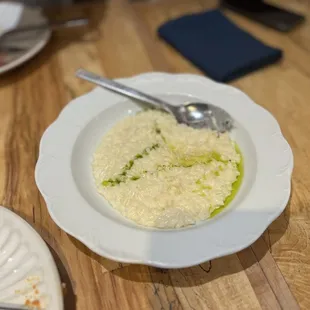 a bowl of rice and a spoon on a wooden table