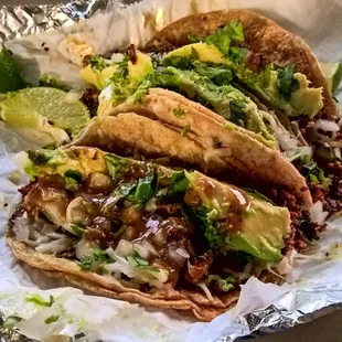 To-go order of 3 Chorizo tacos with cheese and avocado.