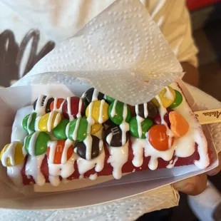 a person holding a sandwich with toppings