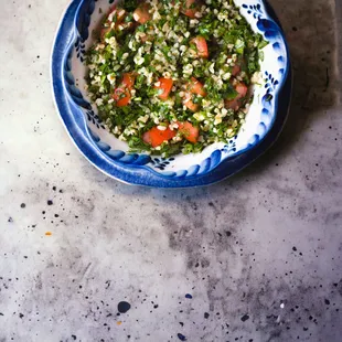 Tabbouli: A vibrant medley of minced, organic parsley, ripe tomato, onion, tender bulgar in a zesty olive oil dressing. Gluten Free. Vegan.