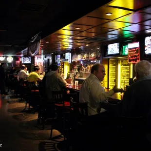 people sitting at the bar and watching televisions