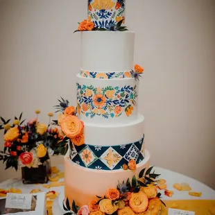 a three tiered cake with orange flowers