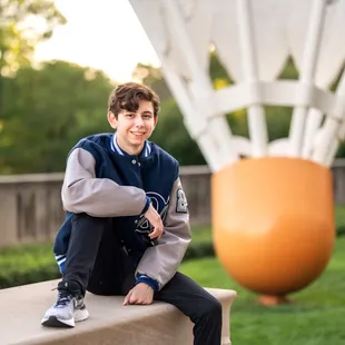 High School Senior boy posing for senior pictures at the Nelson Atkins in Kansas City.