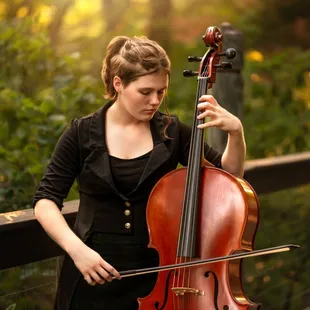 High School Senior girl playing the cello on a bridge in Kansas City.