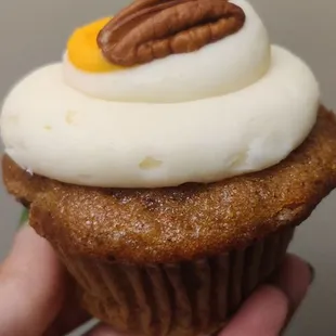 a hand holding a cupcake
