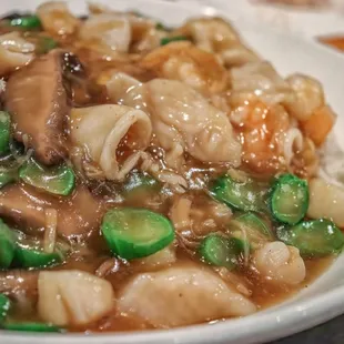 a plate of pasta with mushrooms and peas
