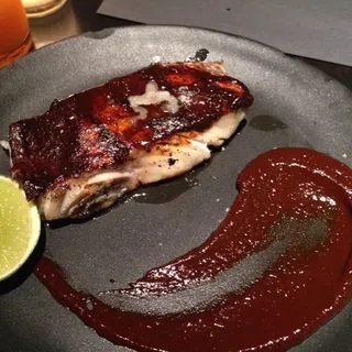 Steamed Black Sea Bass wrapped in Hoja santa leaf, Market shelling beans, Jimmy nardello peppers & sungold tomato juice