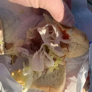 a hand holding a sandwich