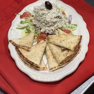 a plate of pita chips and a salad