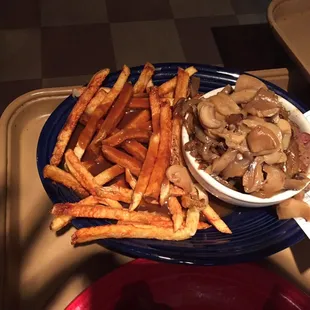 a plate of french fries and a bowl of mushroom gravy