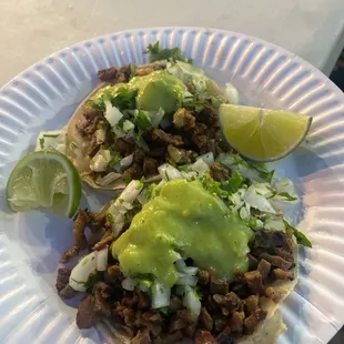 two tacos on a paper plate
