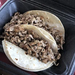 two tacos in a styrofoam container