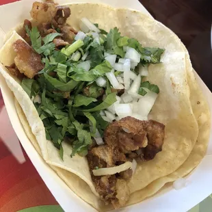 a hand holding a taco