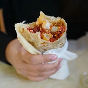 a person holding a burrito