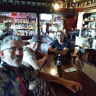 three men sitting at the bar