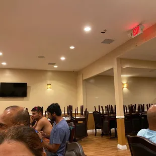 All tables allocated to people in one corner. All empty tables on the other corner, not enabling social distancing for customers.