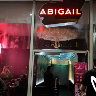 the entrance to a restaurant with a neon sign