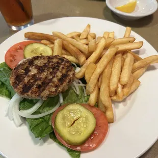 Build Your Own Burger - turner on lettuce bun with fixings and fries.