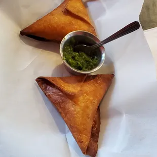 a plate of saman and a bowl of pesto sauce