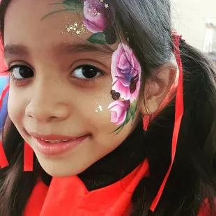 Young girl in costume with rose design at Yosemite Street Village's Wicked Wednesday market
