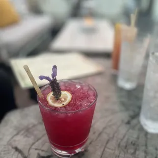 a glass of a drink with a garnish on it