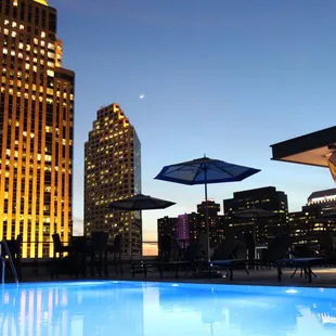 a swimming pool in front of a city skyline